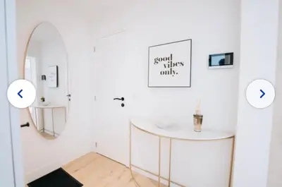a white room with a round table and a mirror at Chic et cosy idéal pour un séjour à Liège in Liège