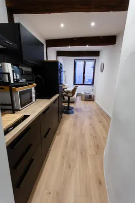 a kitchen with wooden floors and a living room at Le Nid in Liège