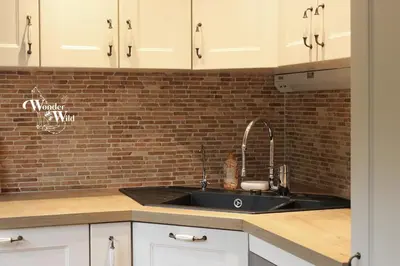 a kitchen with a sink and a brick wall at Wonderwild E87, Connect to nature & Dog Friendly in Lanaken