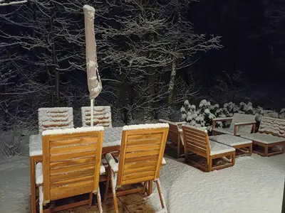 a wooden table and chairs with snow on them at Lysdann Zutendaal in Zutendaal