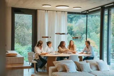 a group of people sitting around a table in a room at Homestorys Nature Resort - Lakeview Pavilion in Eupen