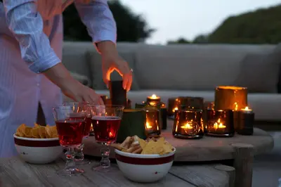 a table with chips and glasses of wine and candles at Homestorys Nature Resort - Lakeview Pavilion in Eupen