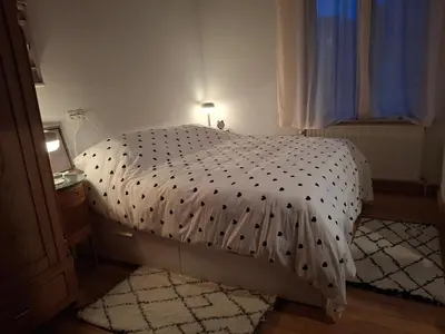 a bedroom with a bed with a black and white comforter at La Vie en Rose in Ensival