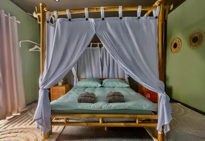 a bed with a canopy in a room at Your wellness break in Dalhem