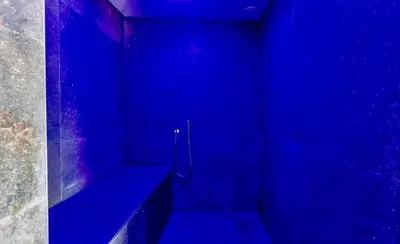 a blue bathroom with a bench in a blue room at Your wellness break in Dalhem