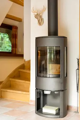 a fireplace in a living room with a staircase at Riet&Rust in Lanaken
