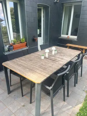 a wooden table and chairs on a patio at House with garden for 4 people in Verviers
