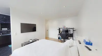 a bedroom with a bed and a desk with a computer at Home cinema in Liège