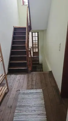 a hallway with stairs and a rug on a wooden floor at Charlemagne house in Liège
