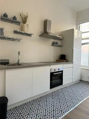 a kitchen with white cabinets and a sink at Luik city center in Liège