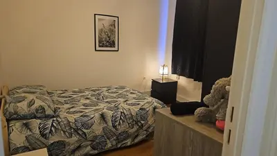 a bedroom with a bed and a lamp in it at Logement Sam in Liège