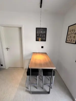 a wooden table in a room with a white wall at Haus Orion in Eupen