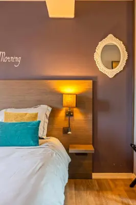 a bedroom with a bed and a mirror on the wall at Hotel Brasserie de Klok in Zutendaal