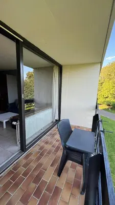 a chair sitting on a patio with a balcony at Serene Oasis - your Idyllic Escape in La Calamine