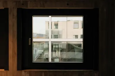 a view of a building through a window at Coliving - Bord de Meuse - L'échappée Mosane in Oupeye