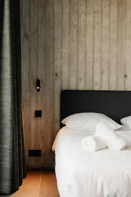 a bed with white sheets and pillows in a room at Coliving - Bord de Meuse - L'échappée Mosane in Oupeye