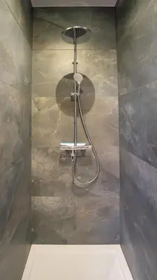 a shower in the corner of a bathroom at Appartement en plein centre-ville in Liège