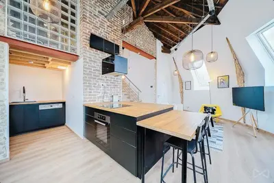 a kitchen with a table and a brick wall at Logement temporaire haut de gamme Particuliers & entreprises in Liège