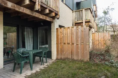 a patio with a table and chairs and a fence at Center Parcs Apartments Erperheide in Peer