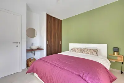 a bedroom with a large bed with a pink blanket at 't Vennehuys in Genk