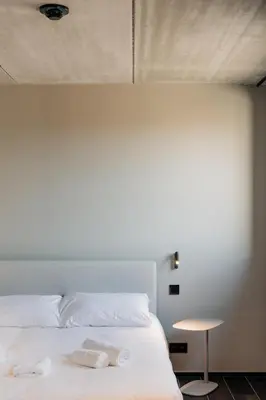 a bedroom with a white bed with towels on it at Coliving - Bord de Meuse - L'écrin Vert in Oupeye