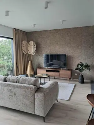a living room with a couch and a flat screen tv at Chez Vincent, parking gratuit in Liège