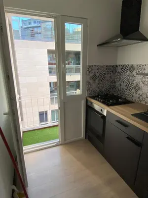 a kitchen with a stove and a window at Studio moderne et confort - Guillemins in Liège