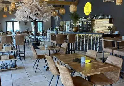 a restaurant with tables and chairs and a bar at Camping Papillon Kinrooi - Pipowagen met terras in Kinrooi