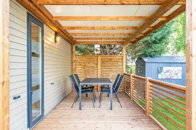 a wooden deck with a table and chairs on it at Camping Papillon Kinrooi - Vakantiehuis Familie 6P in Kinrooi