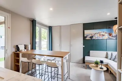 a kitchen and living room with a table and chairs at Camping Papillon Kinrooi - Vakantiehuis Familie 6P in Kinrooi