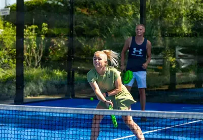 a woman holding a tennis racket on a tennis court at Camping Papillon Kinrooi - Vakantiehuis Familie 6P in Kinrooi