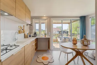 a kitchen with a table and a dining room at Camping Papillon Kinrooi - Vakantiehuis Premium 4P in Kinrooi