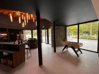 a room with a ping pong table and a bar at L'Orée des Thermes in Chaudfontaine