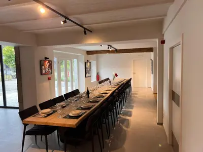 a long table with chairs and a long table with wine glasses at L'Orée des Thermes in Chaudfontaine