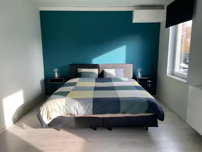 a bedroom with a bed with a blue wall at JoHa Haus in Hasselt