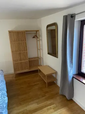 a room with a bed and a table and a mirror at Le Havre de paix in Oupeye