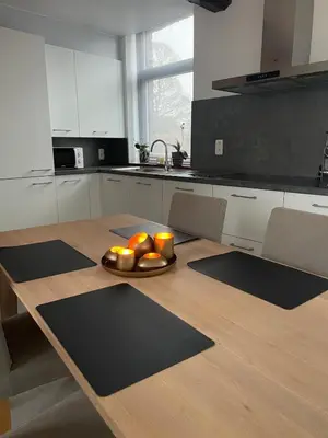 a kitchen with a table with a plate of oranges on it at Le Havre de paix in Oupeye