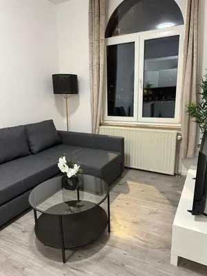 a living room with a couch and a glass table at 1 Chambre et Sofa Bed en plein cœur de Liege in Liège