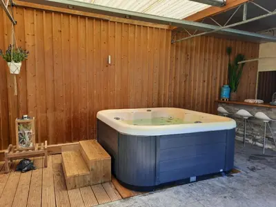 a jacuzzi tub in a room with a wooden wall at Holiday Home Mooi - Voeren in Voeren