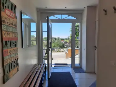 a hallway with a bench and an open door at Holiday Home Mooi - Voeren in Voeren