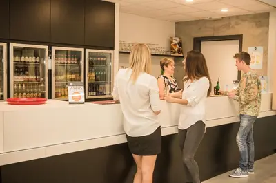 a group of people standing at a counter at Hostel H in Hasselt