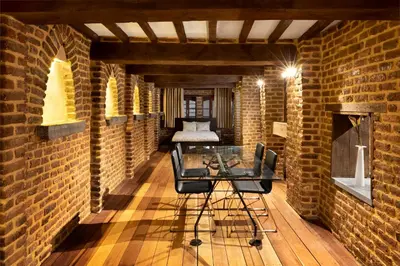 a brick room with a glass table and a bed at Appart-Hotel Léopold Liège Centre in Liège