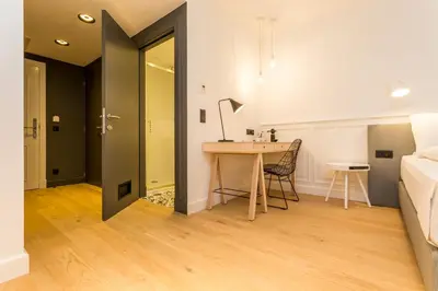 a room with a desk and a bed and a table at De Sjeiven Dorpel in Maaseik