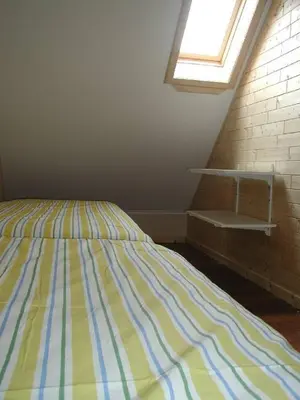 a bedroom with a bed with a yellow and blue stripes at De Bosbeekpoort in Oudsbergen