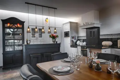 a dining room with a table and chairs and a kitchen at Tussen Hemel en Maas in Dilsen-Stokkem