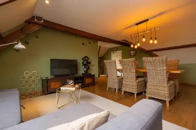 a living room with a couch and a table with chairs at Het Hemelsveld in Hasselt