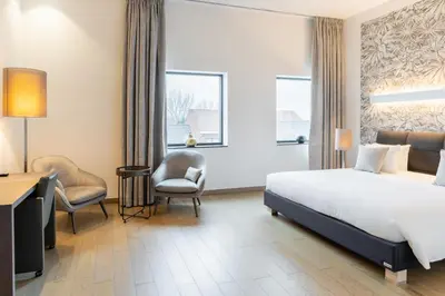 a hotel room with a bed and a desk and chair at Hotel Stayen in Sint-Truiden