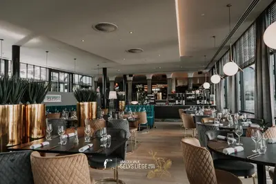 a restaurant with tables and chairs and windows at Van Der Valk Sélys Liège Hotel & Spa in Liège