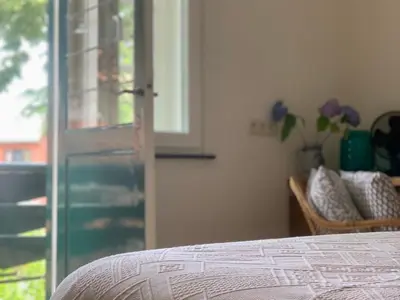 a bedroom with a bed and a sliding glass door at Vakantiewoning Guesthouse MOMO in Dilsen-Stokkem