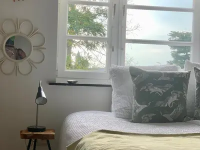 a bedroom with a bed with a mirror and a window at Vakantiewoning Guesthouse MOMO in Dilsen-Stokkem